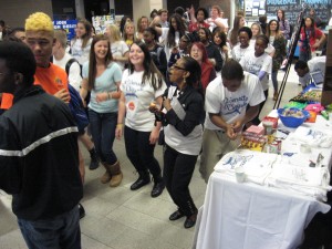 A group of students dance in the commons area.