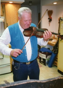Uncle Vince "fiddles" with his Dad's farmhouse fiddle, Oct 1992.  Grandpa had a country band and learned violin by use of sheet music.  